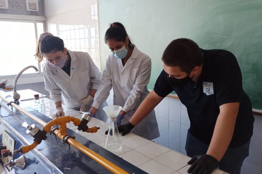 Agustín Mangüello, Victoria Wesner y Karla Buscamante, creadores de un filtro para microplásticos del lavarropas, en el laboratorio del colegio donde hicieron el desarrollo / Gentileza equipo Kartic