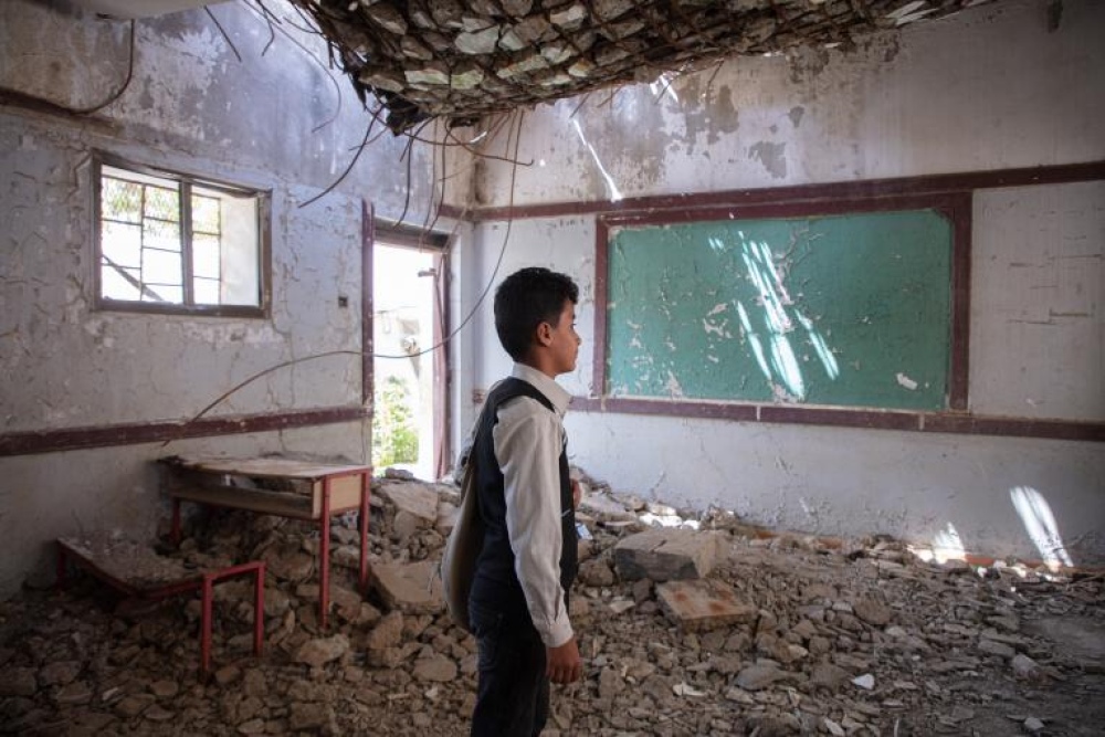 Ahmed, de 12 años, observa su aula destrozada por un bombardeo en Hajjah, Yemen. Las armas explosivas usadas en ataques a escuelas tienen un efecto especialmente devastador sobre las instalaciones, los profesores, estudiantes y trabajadores. Foto: Marish/