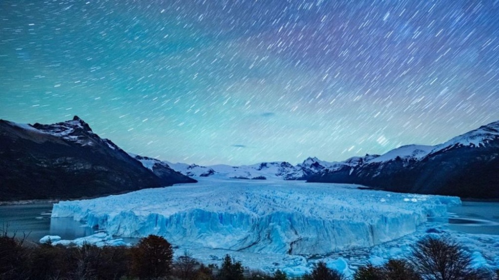 La impactante foto del glaciar Perito Moreno en la que se observan luces y haces de luces a la derecha. La exposición fue de seis minutos, por eso las estrellas se ven como trazas. Foto: Rodrigo Terrén. 